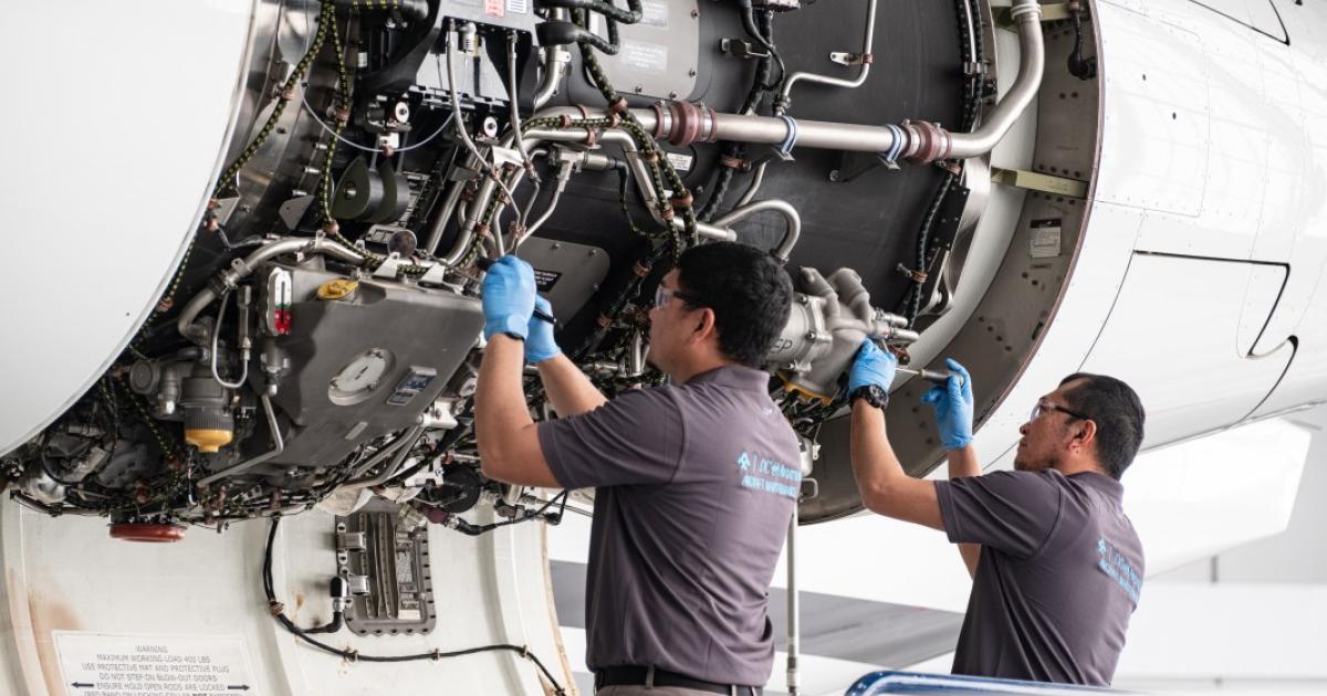 Two technicians inspecting open aircraft panel 
