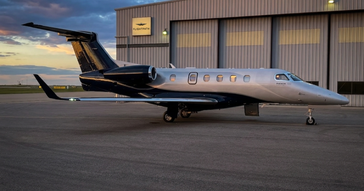 A Phenom 300E parked in front of the Flightpath hangar in Calgary at dusk