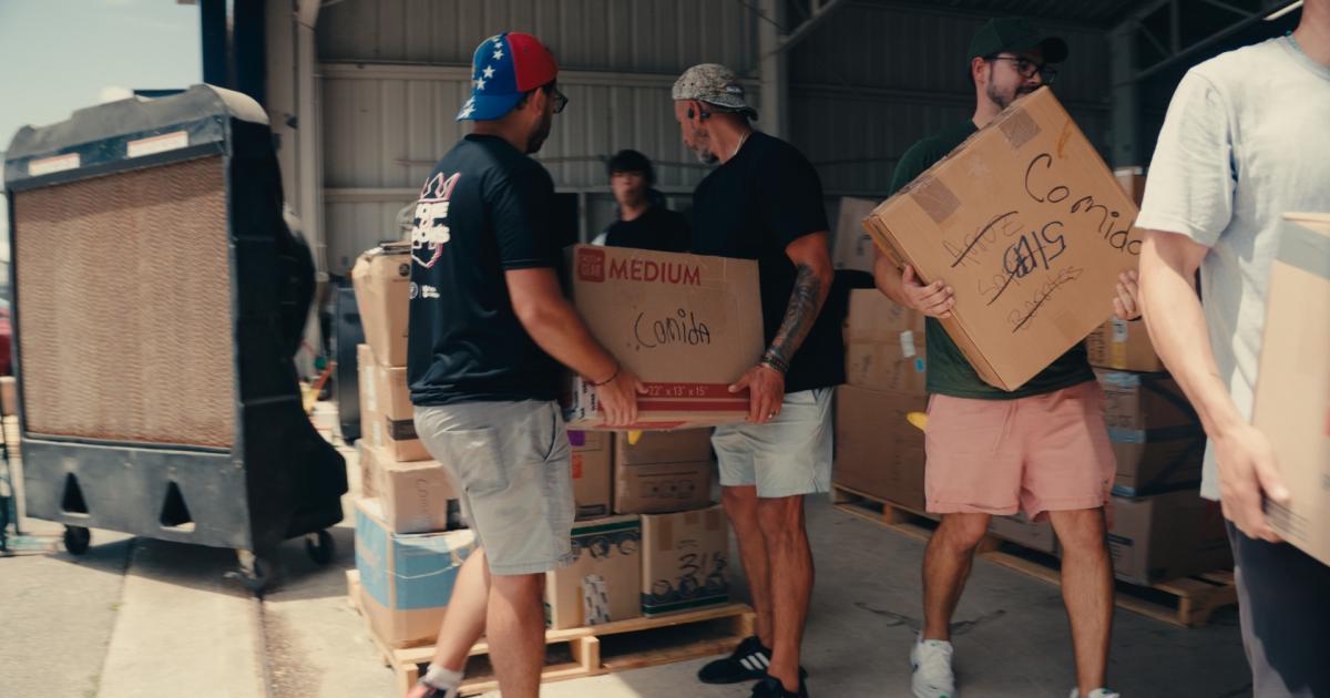 Volunteers pass boxes for a Hope on Wings mission