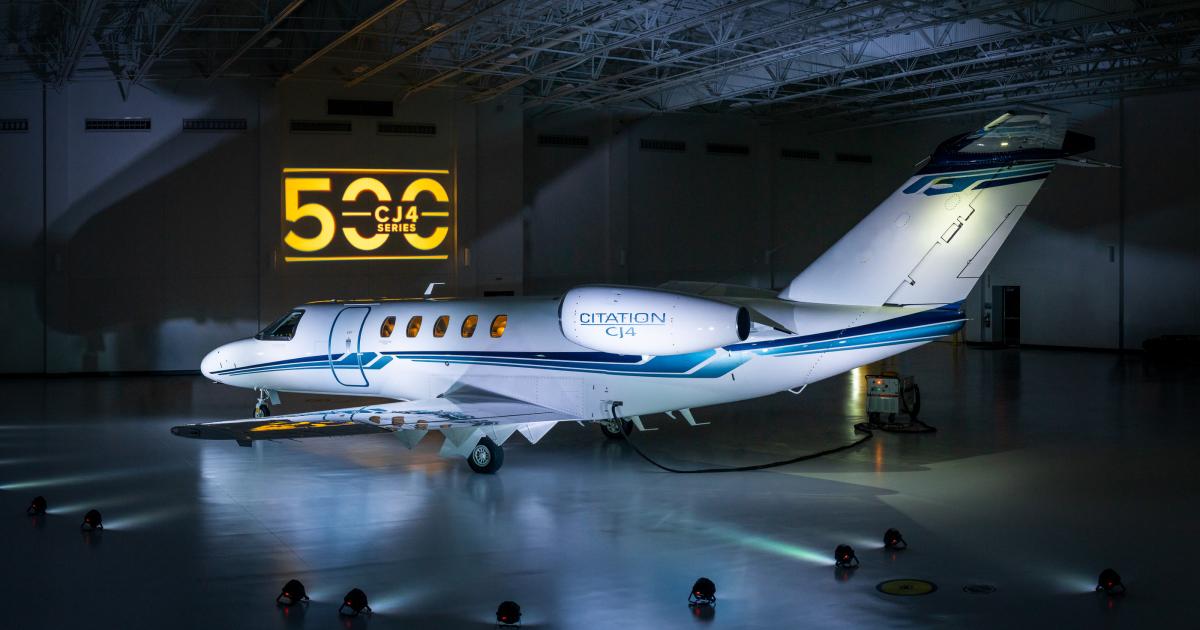 A Citation CJ4 lit dramatically in a hangar with the number 500 projected on the wall behind it