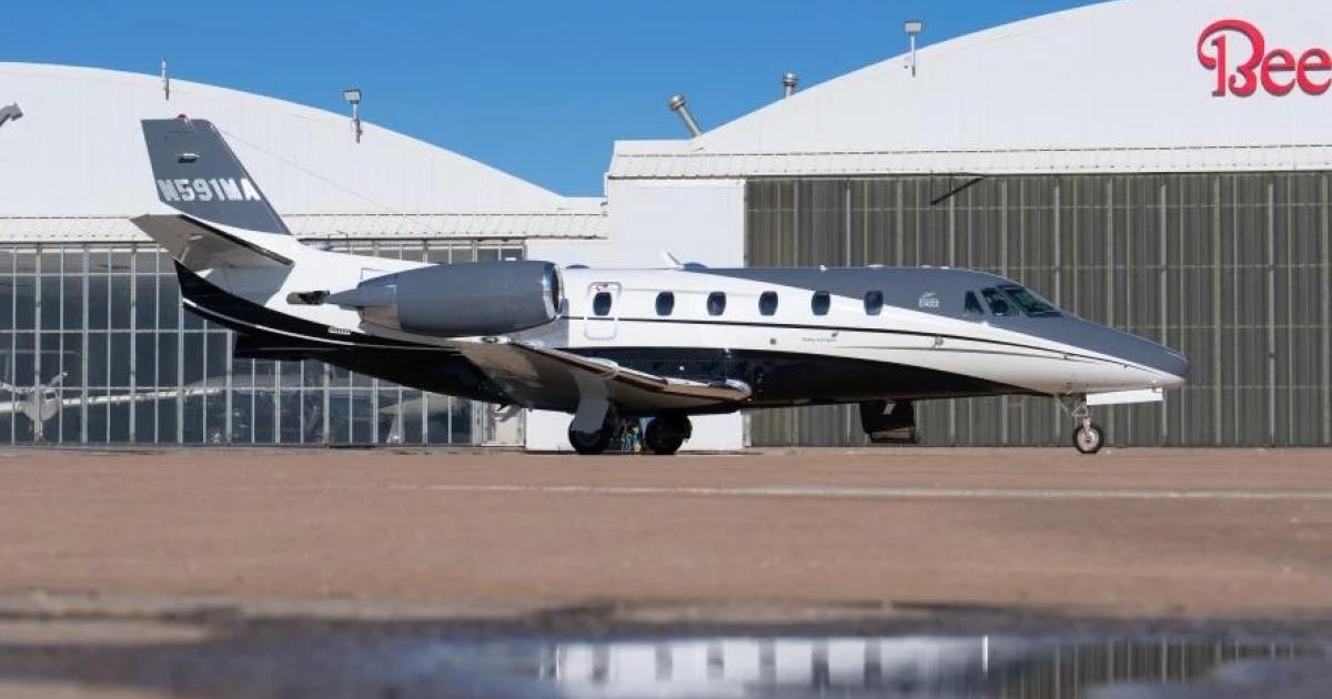 a business jet in front of a hangar