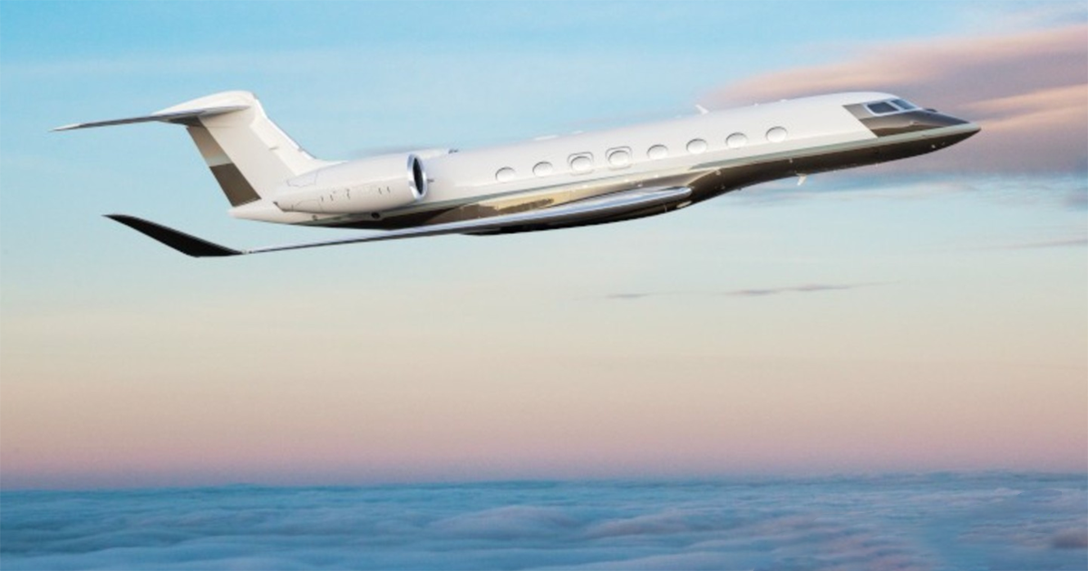 A Gulfstream G800 in flight above clouds at dusk