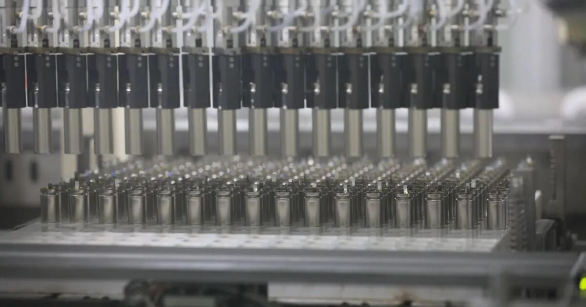 Rows of cylindrical battery cells on a production line