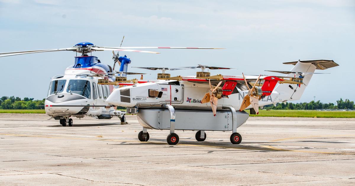 Elroy Air’s hybrid-electric Chaparral cargo drone is parked beside a helicopter from Bristow