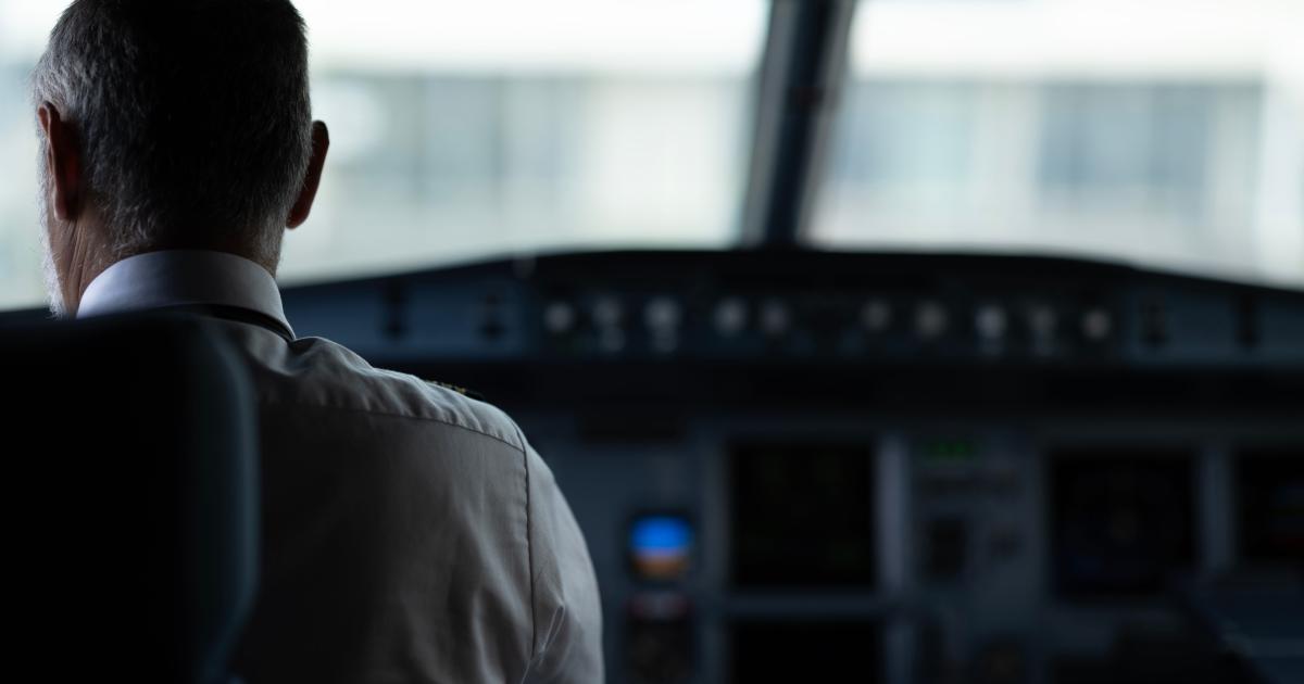 A focused view of an airline pilot in the cockpit, emphasizing responsibility and aviation control.