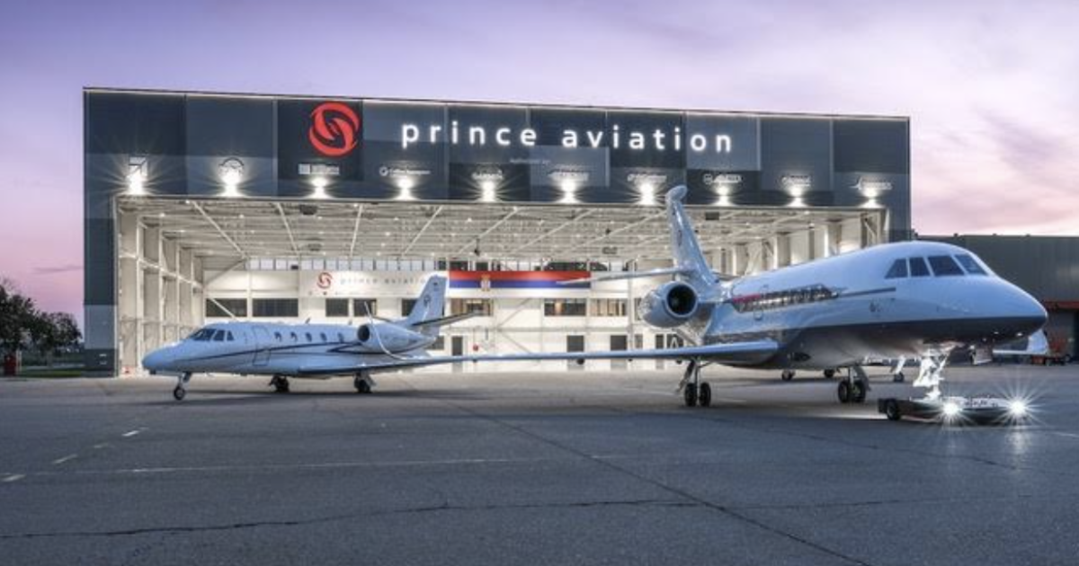 Two jets on ramp outside maintenance hangar at night time 