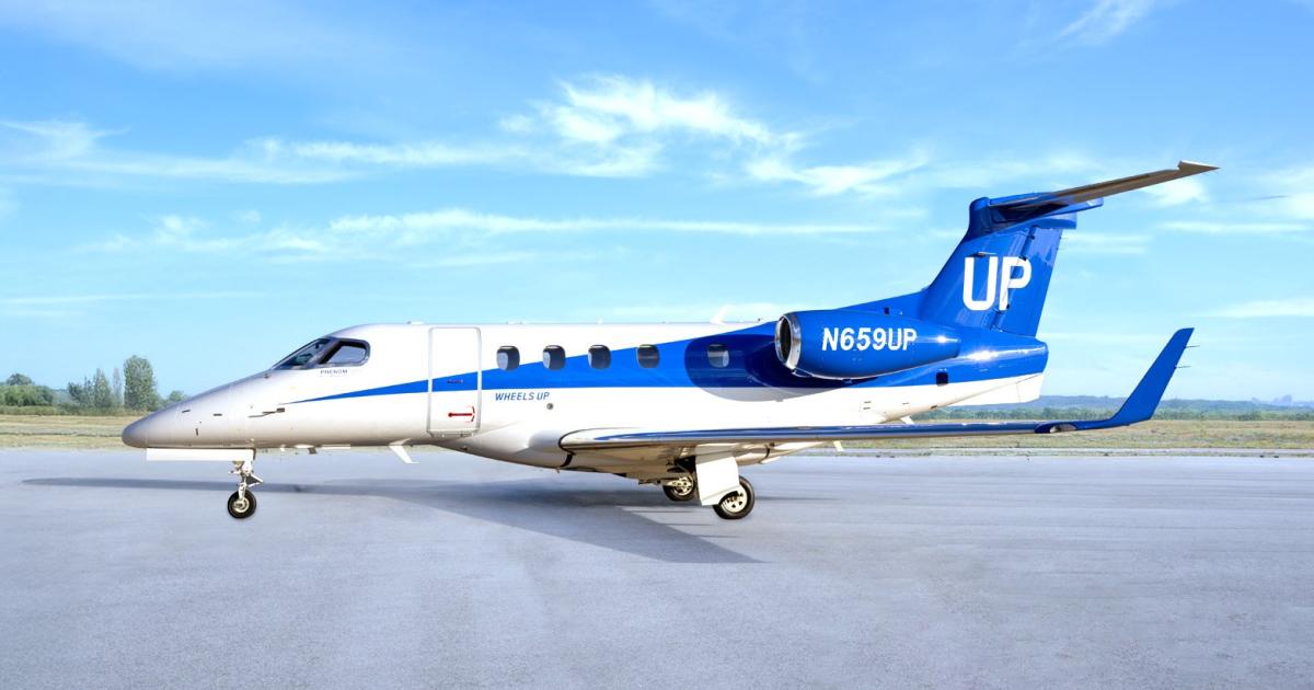 Blue and white Wheels Up liveried Phenom 300 on tarmac 