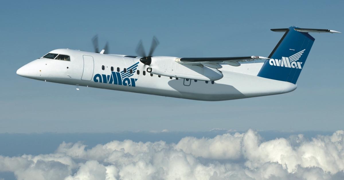 An Avmax Dash 8-300 flies above a layer of clouds.