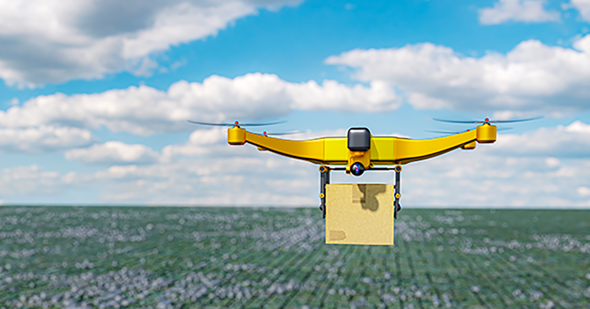 A yellow delivery drone flies over a field