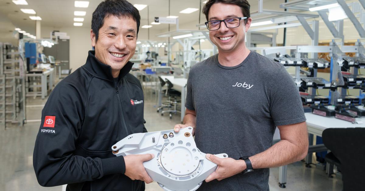 Two Joby engineers are pictured holding a tilt actuator at Joby’s San Carlos production facility.