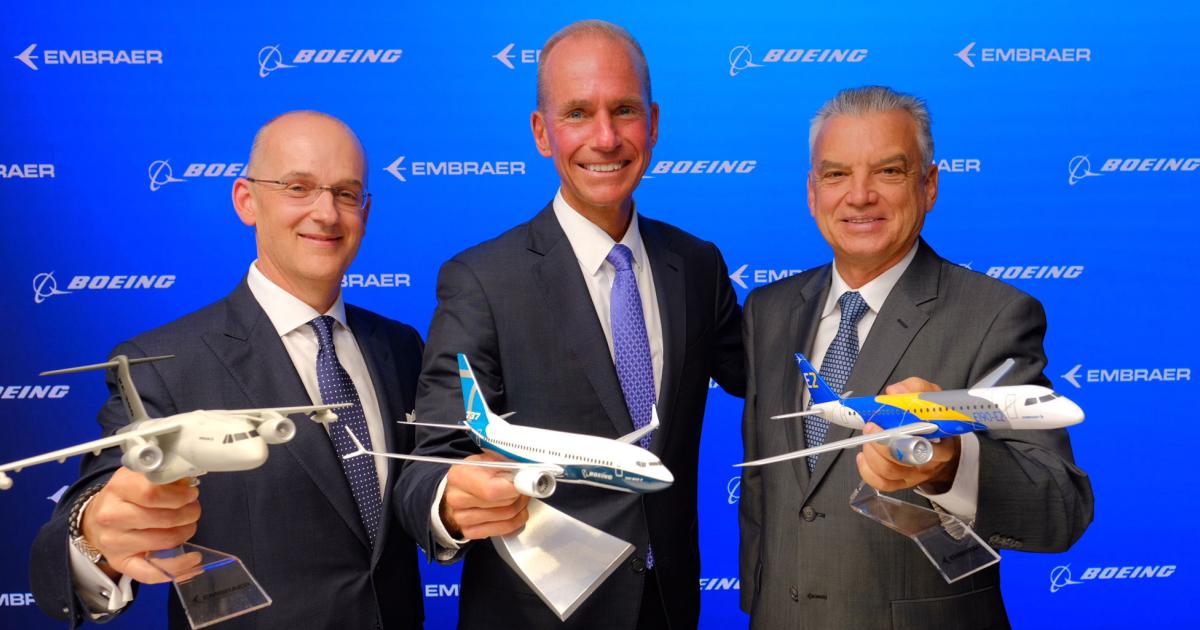 Boeing CFO Greg Smith (left), Boeing CEO Dennis Muilenburg (center), and Embraer CEO Paulo Cesar Silva celebrate their respective companies’ recent joint-venture announcement.
