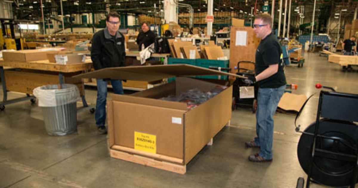 Joseph Gettings (left), team leader for kit assembly at Boeing’s Spares Distribution Center, and Chad Howell, shipping facilitator, prepare a battery containment kit for shipping to a 787 customer. (Photo: Katie Lomax) 