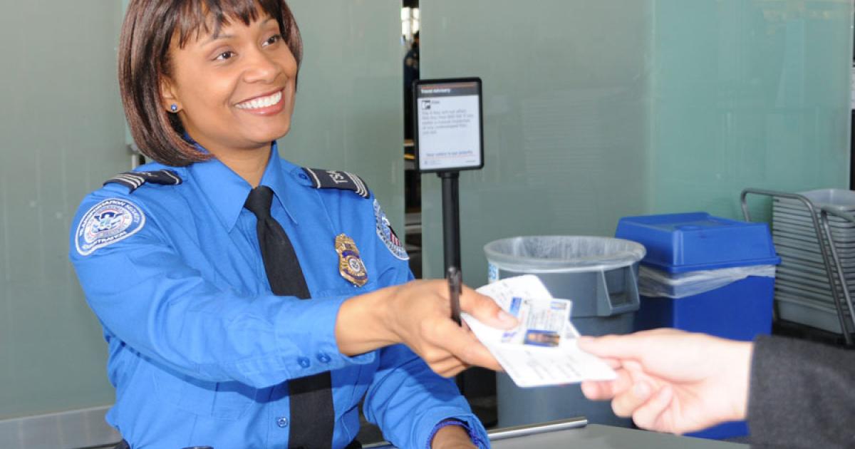 A transportation security officer with the U.S. Transportation Security Administration checks a passenger’s identification. (Photo: TSA)
