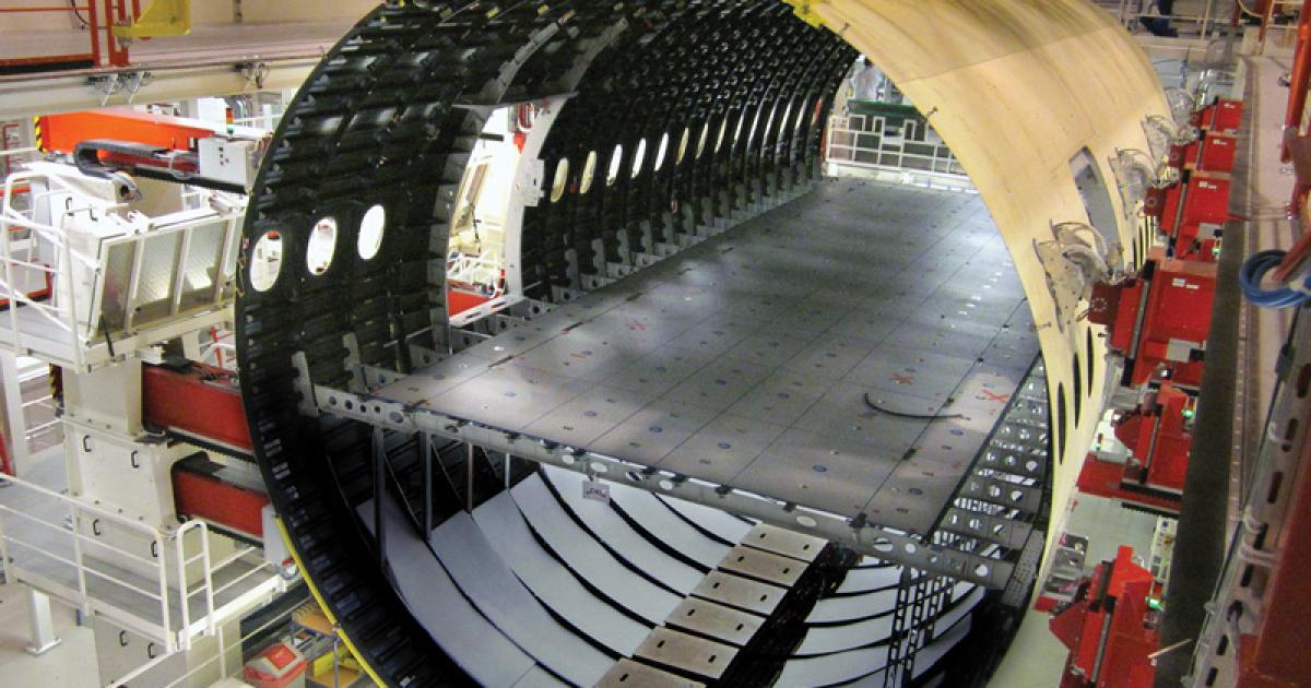This forward fuselage section of an Airbus A350 awaits the center section. Late deivery of composite skin panels, wing spars and trailing edge assemblies have delayed the program.