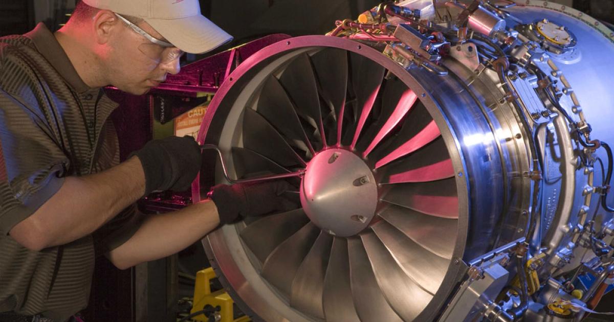A Dallas Airmotive engine technician completes final installation of a PW500 spinner.