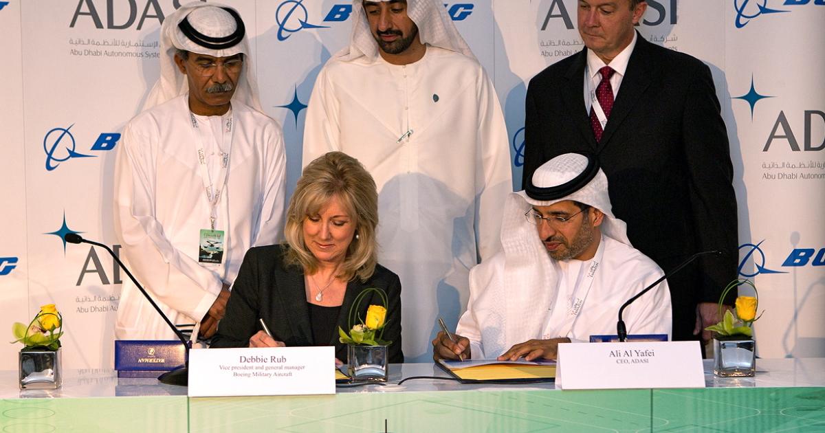 Debbie Rub, Boeing Military Aircraft vice president and Ali Al Yafei, Adasi CEO, sign the UAS teaming agreement at the IDEX conference in Abu Dhabi. (Photo: Boeing)