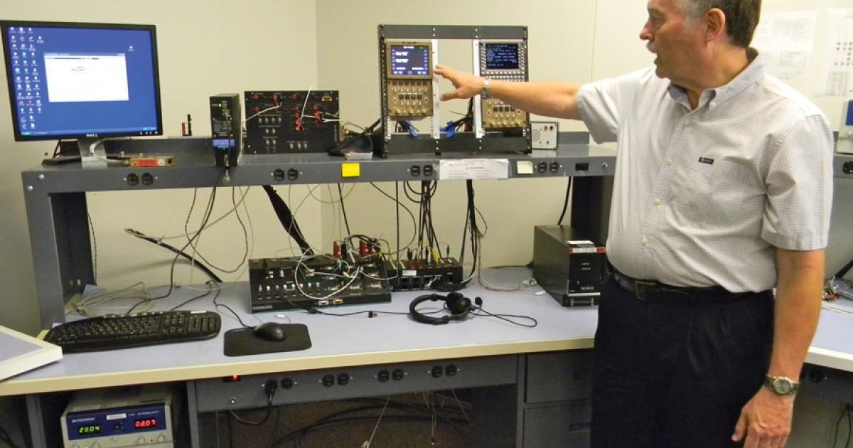 Bruce Bell, ICG technical support manager, points out components of a Fans-equipped flight deck, including an external SIM card reader and ICG’s ICS-120A Iridium communications system on the top shelf.
