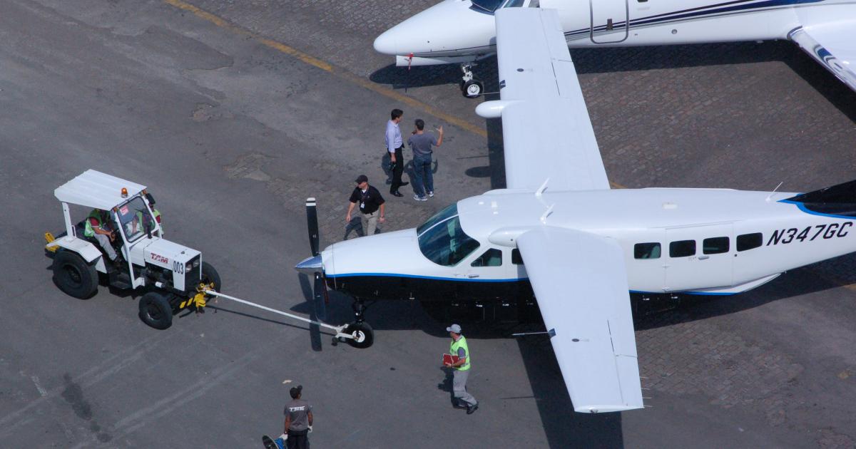 Swissport ground handlers position a Cessna Grand Caravan during setup of the aircraft static display at LABACE 2012.