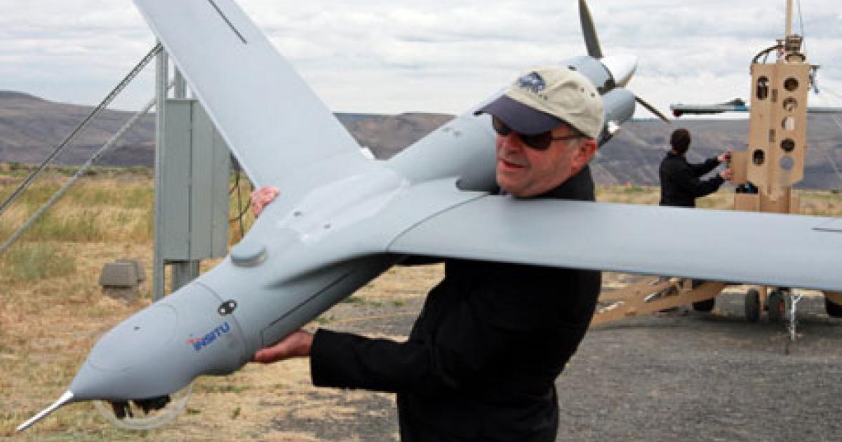 AIN Defense Perspective editor Chris Pocock gets up close and personal with a Scan Eagle UAS at Insitu’s test site in Oregon. The UAV’s catapult launch and recovery sling rig is visible in the background. (Photo: Boeing)