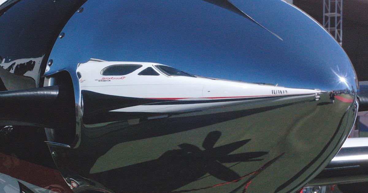 A Beechcraft King Air 350i presents a sleeker image reflected in a propeller spinner reflection at the Líder Aviação exhibit at LABACE 2013 in São Paulo.