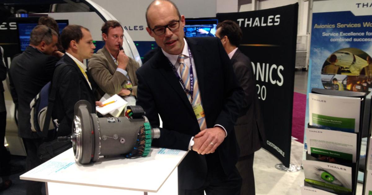 Guy Lefebvre, president of Thales Avionics Electrical Systems, shows off a main engine AC starter-generator which is being developed for the new Dassault Falcon 5X. (Photo: Bill Carey)