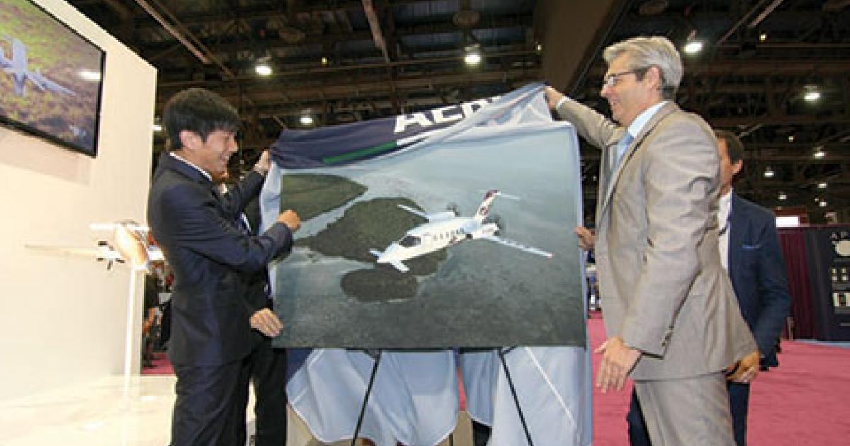 SR Jet president and executive director Xingzhuo Ji (l) and Piaggio Aero deputy general manager and chief commercial officer Giuliano Felton unveil a rendering of what SR Jet's extended-range Avanti II twin turboprops will look like. (Photo: Mariano Rosales/AIN)