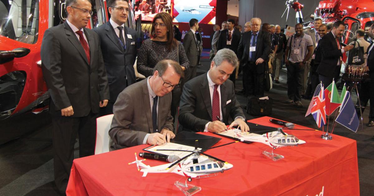Richard Burman, CEO Omni Helicopters International, left, and Daniele Romiti, CEO, AgustaWestland, sign the purchase agreement for four AW139s and five AW189s, all for use in oil and gas operations. (Photo: Mariano Rosales)