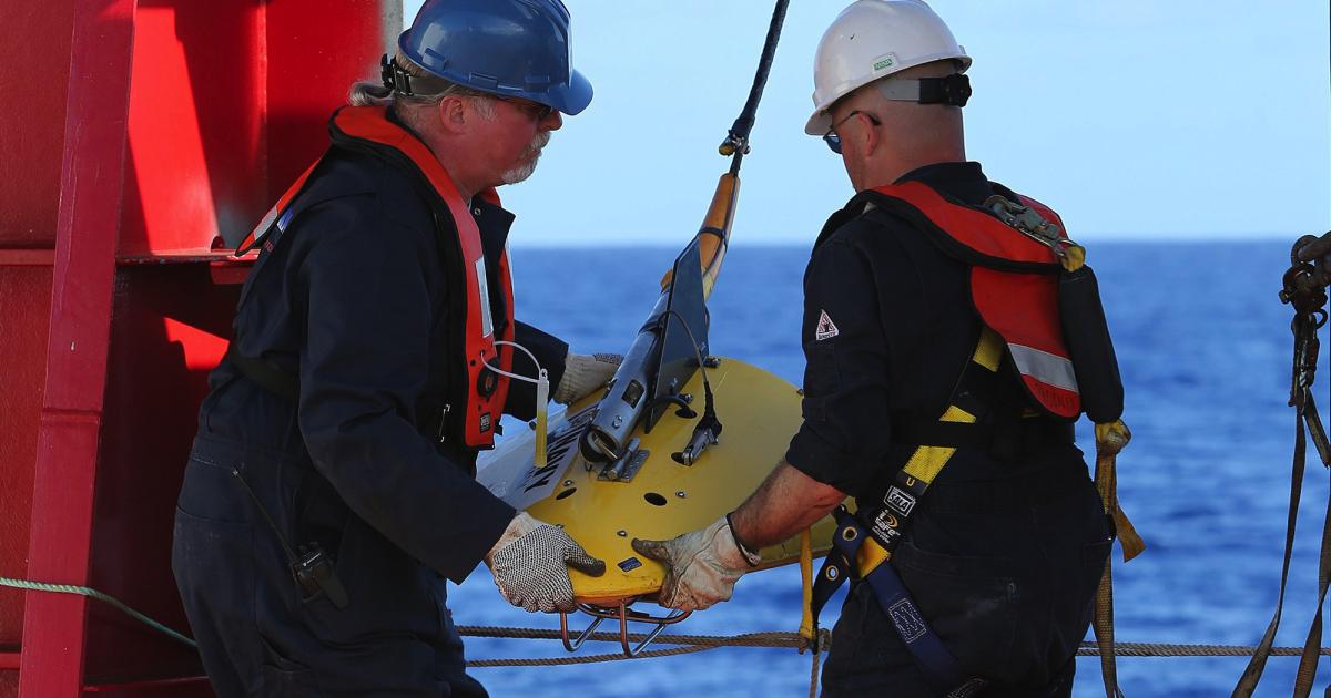 Phoenix International personnel deploy the towed pinger locator made by their company off the deck of the Royal Australian Navy vessel Ocean Shield. (Photo: Royal Australian Navy)