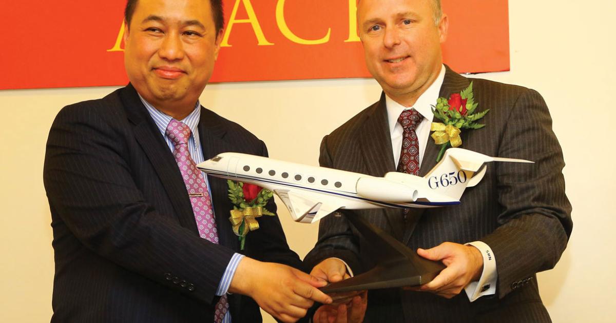 Scott Neal, Gulfstream’s senior vice president for sales and marketing, and Johnny Lau, head of Minsheng’s aircraft leasing division, celebrate a blockbuster order signed today at ABACE for 40 business jets with options for 20 more. The deal is believed to be confirmation of an estimated more than $2.6 billion MoU signed in 2011. (Photo: David McIntosh/AIN)