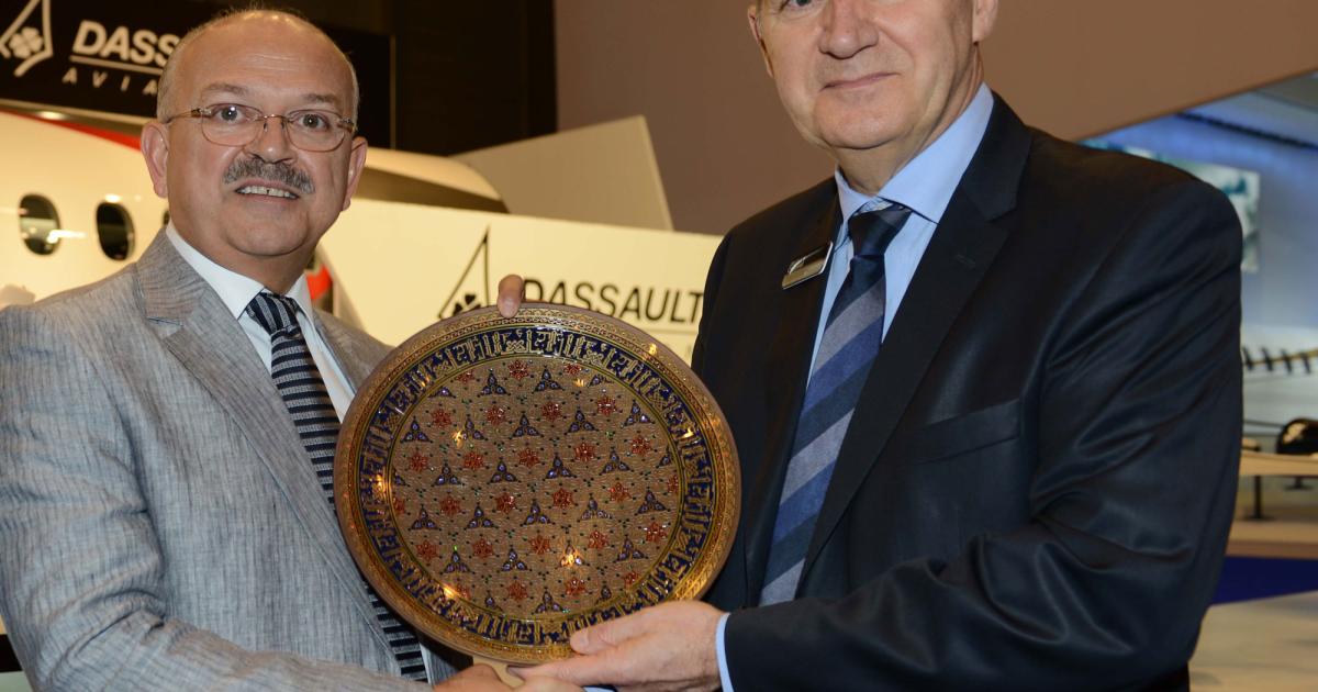 Jacques Chauvet, Dassault senior vice president of worldwide Falcon customer service (right), presents the authorized service center plaque to Kadri Muhiddin, group executive chairman and CEO of Amac Aerospace, at EBACE.