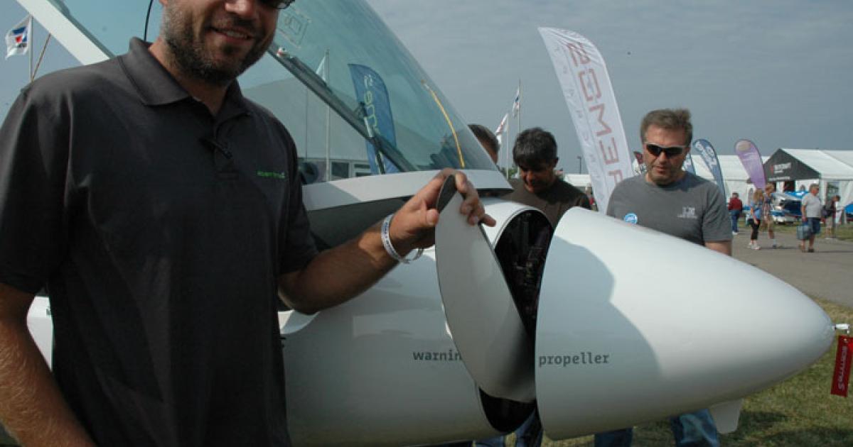 Stemme demonstration pilot Andreas Hebner holding a blade from the motor glider's hub at AirVenture 2014.