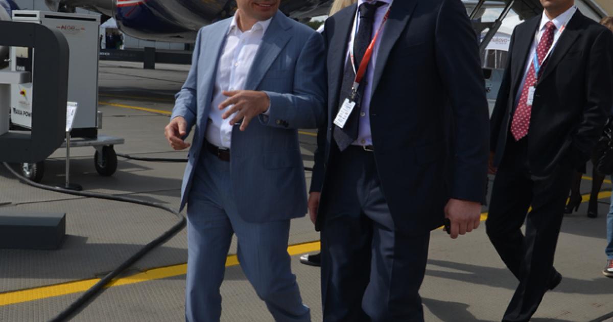 Vnukovo co-owner Vitaly Vantsev, left, and Vnukovo-3 general director Georgy Sharov walk the ramp in front of Sukhoi's VIP Superjet during JetExpo'2014.