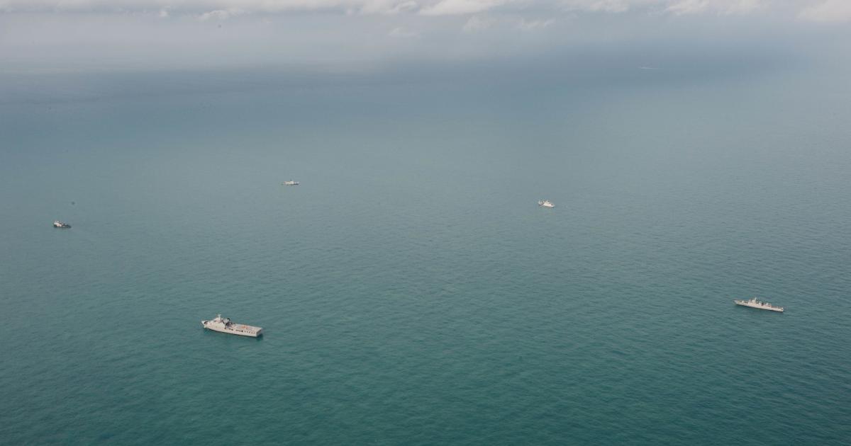 A multinational grouping of naval vessels participates in search operations at the location of AirAsia Flight QZ8501’s tail in the Java Sea. (Photo: U.S. Navy)