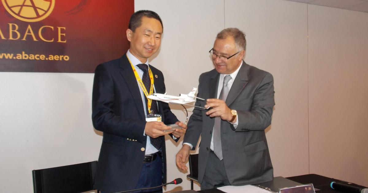 Deer Jet president Zhang Peng (left) accepts a model of a Falcon 7X from Dassault v-p for civil aviation Olivier Villa. Deer Jet will support the 7X. Photo: Curt Epstein
