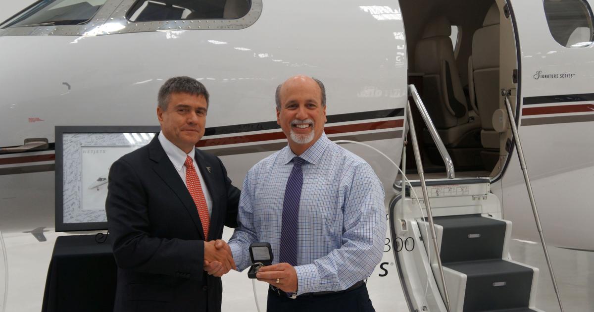 Embraer Executive Jets president and CEO Marco Túlio Pellegrini hands over the keys to the 100th U.S.-assembled Phenom 300 to NetJets senior vice president of global asset management Chuck Suma. The light jet is also the 40th Phenom 300 to be delivered to the company. (Photo: Chad Trautvetter)