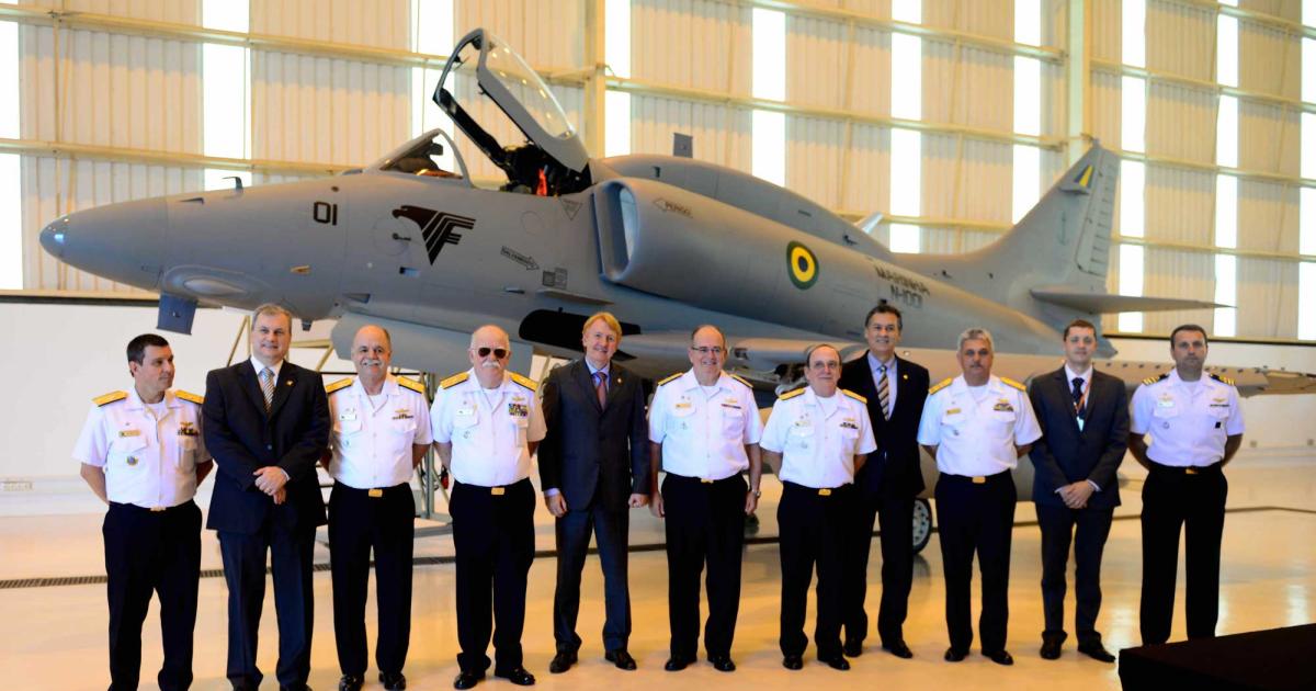 Officials from Embraer and the Brazilian Navy line up in front of the first modernized A-4 Skyhawk during delivery ceremony. 