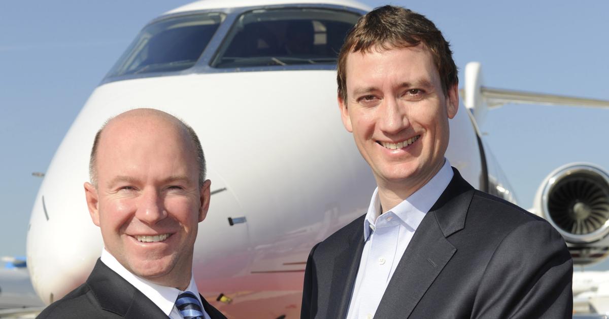 Bombardier president and CEO Alain Bellemare hands the keys for NetJets’ first Challenger 350 to NetJets chairman and CEO Jordan Hansell. (Photo: Mark Wagner/AIN)