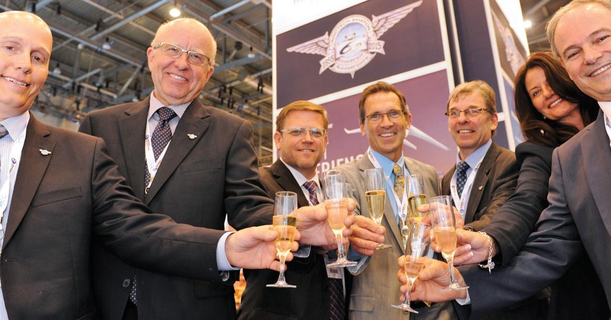 Innotech Aviation president Kirk Rowe, left, leads his colleagues in a toast celebrating 60 years in corporate aviation.