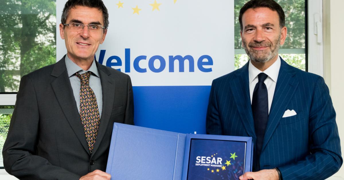 Maurizio Castelletti, l, with the European Commission, accepts program from Massimo Garbini. (Photo: Sesar Deployment Manager)