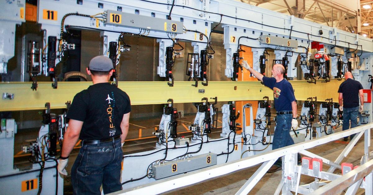 Boeing mechanics start work on the first 737 Max 8 wing. (Photo: Boeing)