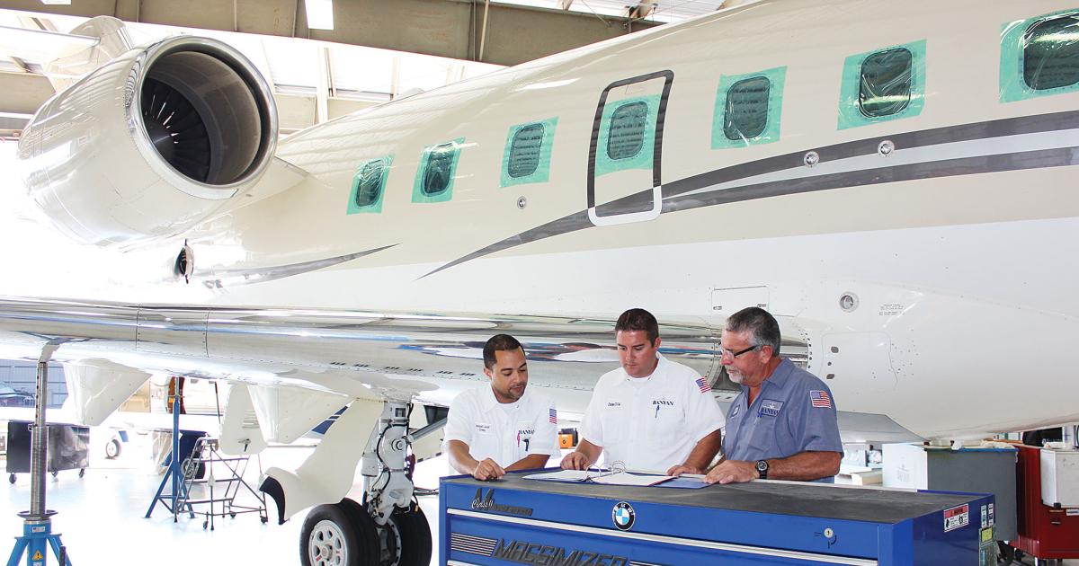 Banyan’s Craig Chin, avionics installation lead coordinator (left), reviews the Challenger 604 work order along with Charles Amento, director of maintenance (center), and Curtis Florio, maintenance crew leader.