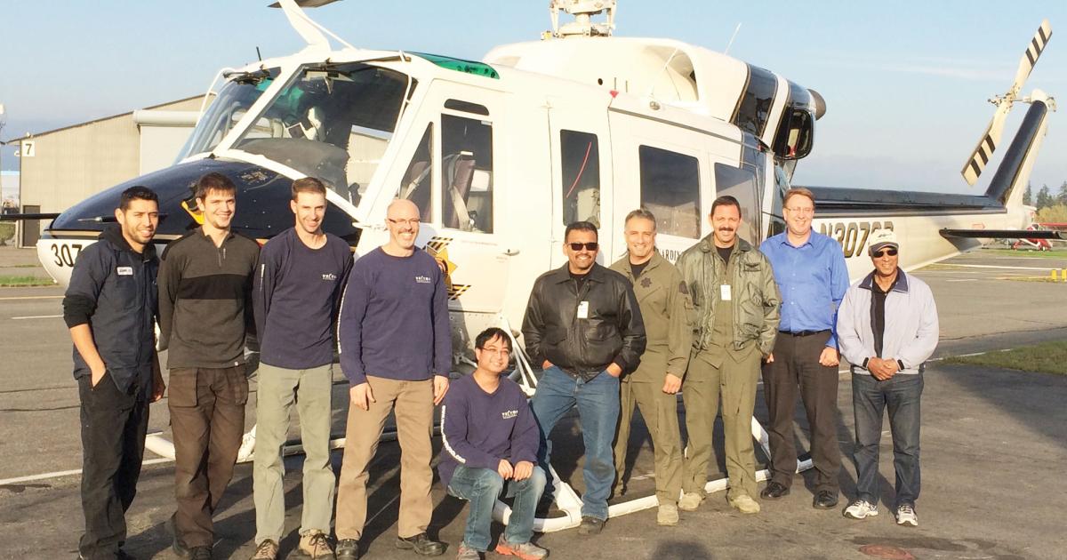 Vector employees and members of the San Bernardino County Sheriff Department pose with the Bell 212 the company modified for the agency.