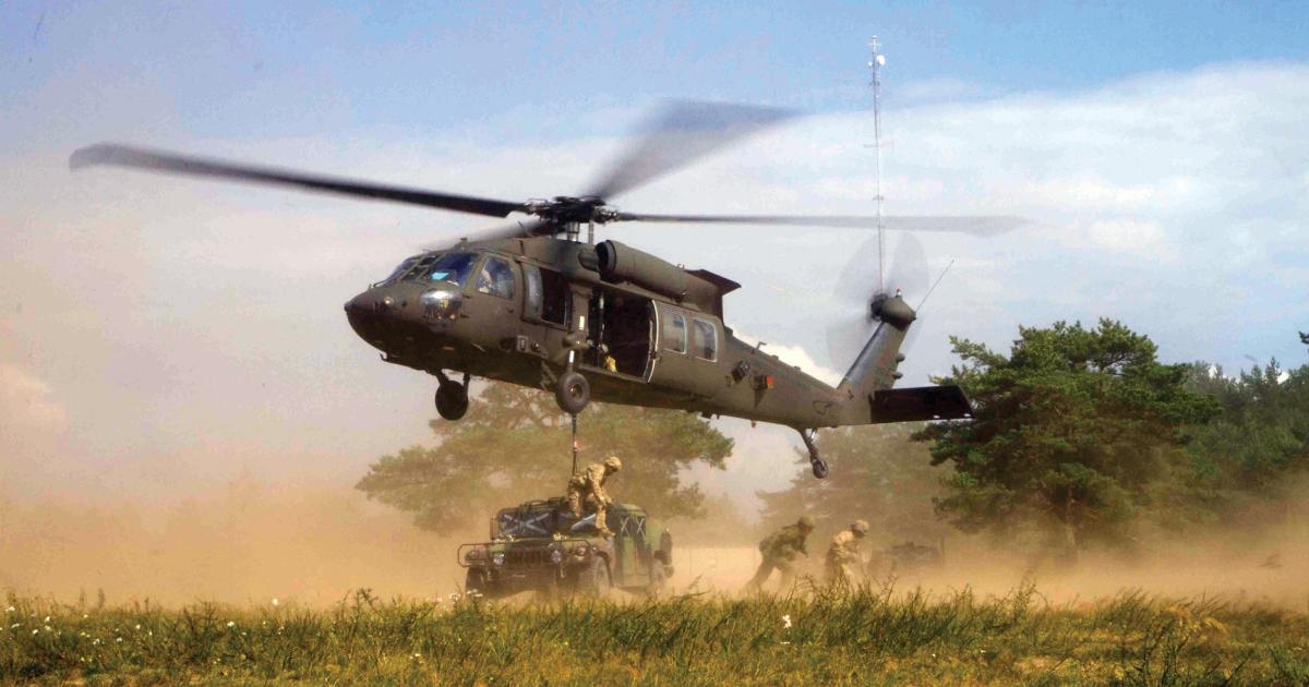 A U.S. Army UH-60M Blackhawk helicopter hovers after sling-loading a high mobility multipurpose wheeled vehicle.