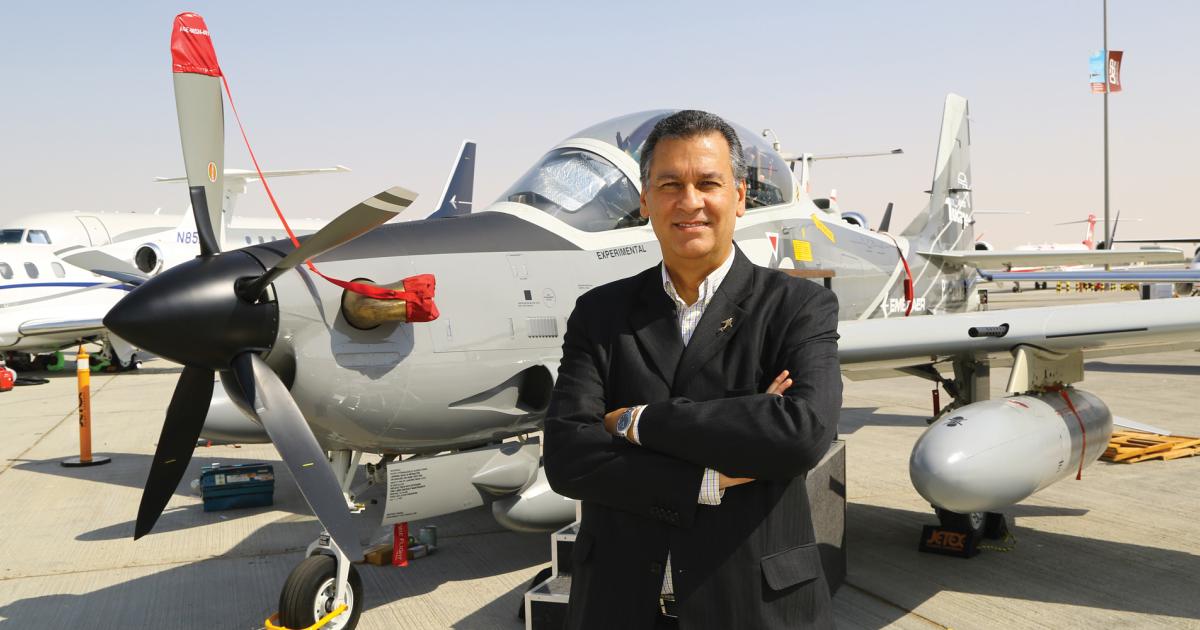 Embraer Commercial senior vice president José Luis Molina strikes a pose in front of his company’s just-arrived A-29 Super Tucano.