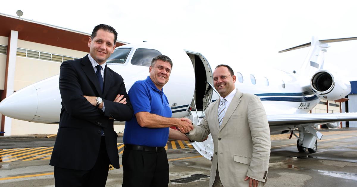 Embraer Executive Jets president & CEO Marco Tulio Pellegrini (center),  shakes hands with Stéphane Ledermann CEO and founder of Smart Air SA  on the occasion of the delivery of the first EASA-registered Legacy 450, while Embraer Executive Jets regional sales director Alessandro Scarpellini looks on.