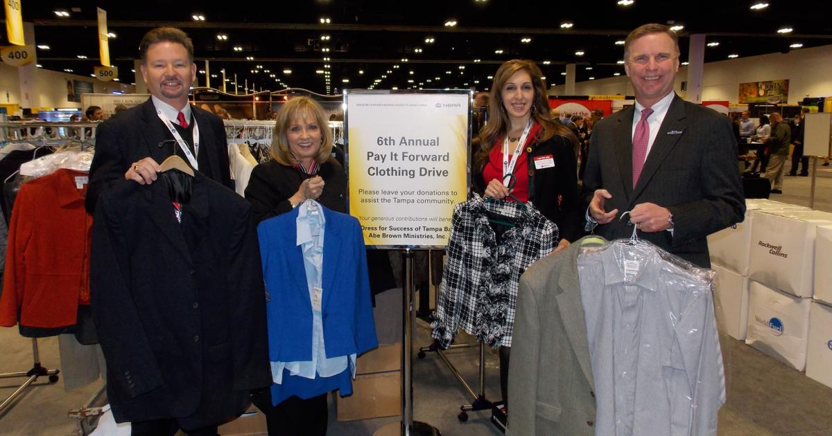 Universal Weather & Aviation's Kevin Tipton and Anabel Monson (second from right) join Pay-it-Forward co-founder and S&D advisory council member Debbi Laux and NBAA president and CEO Ed Bolen to display some of the nearly 4,400 garments worth more than $100,000 donated at this year's Schedulers and Dispatchers Conference to benefit Tampa's disadvantaged. In addition to contributing 1,500 brand new shirts and blouses, Universal collected an entire rack of pre-owned business attire from its employees, and as a major sponsor of the clothing drive also donated the more than $400 in proceeds from a carnival-style claw-machine featured at its booth in the exhibit hall.