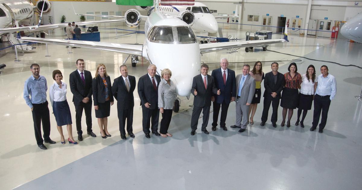 Embraer Executive Jets president and CEO Marco Túlio Pellegrini (center right) and company employees, celebrated delivery of the 30th Phenom with Executive AirShare’s leadership team. This Phenom 300 is painted in colors from the Brazilian flag and features an American and Brazilian flag painted on the vertical stabilizer.  (Photo: Matt Thurber)