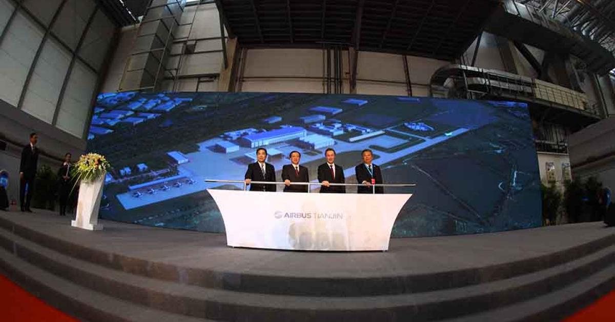 From left to right, Tianjin vice mayor Duan Chunhua, China’s National Development and Reform Commission vice chairman Lin Nianxiu, Airbus president and CEO Fabrice Brégier and AVIC chairman Lin Zuoming pose in front of a rendering of the new A330 completion and delivery center in Tianjin, China.  (Photo: Airbus) 

