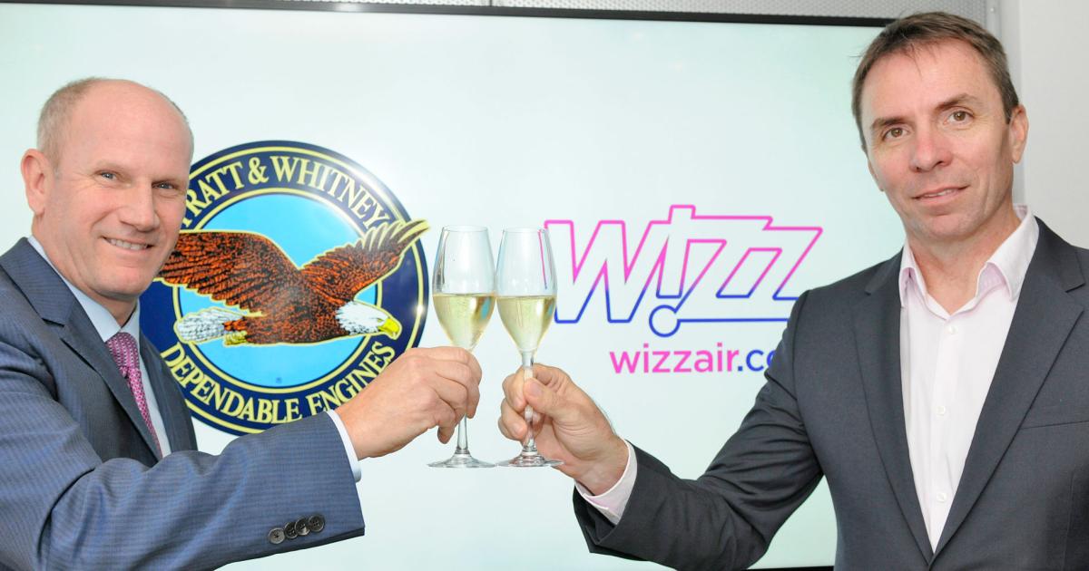 Pratt & Whitney’s Rick Deurloo, left, raises a glass with Wizz Air CEO Jozsef Varadi, celebrating an agreement to buy P&W’s geared turbofan (GTF) engines.