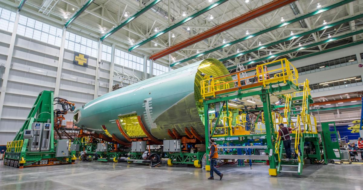 Top, a 777 aft fuselage sits in mobile cradles as a robot is positioned to fasten its panels as part of Boeing’s FAUB process in Everett, Washington.

